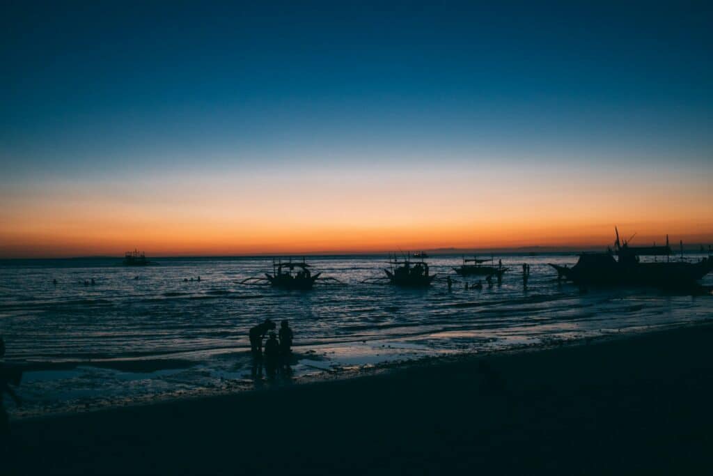 Silhouettes of wooden fishing boats on the sea at sunset
